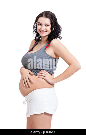 Junge frau mit Babybauch in erwartungsvoller Haltung als Nahaufnahme isoliert vor weißem Hintergrund Stock Photo