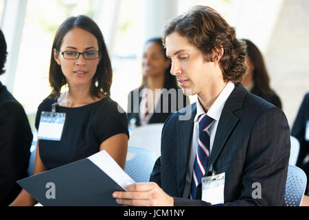 Businessman Discussing Conference Document With Colleague Stock Photo