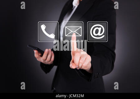 Digital composite image of businesswoman sending message through smart phone over colored background Stock Photo