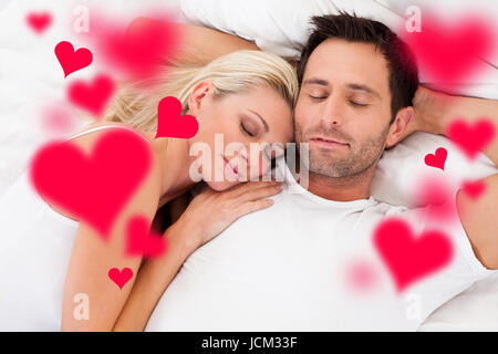 Digital composite image of loving young couple sleeping in bed Stock Photo