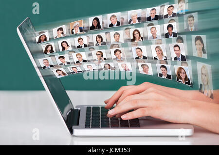 Cropped image of hands using laptop with businesspeople collage Stock Photo