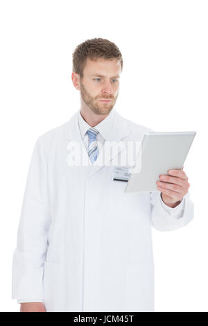 Smiling young male doctor using digital tablet over white background Stock Photo