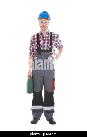 Full length portrait of confident architect holding rolled blueprints and tool kit over white background Stock Photo