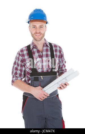 Portrait of confident architect holding rolled blueprints over white background Stock Photo