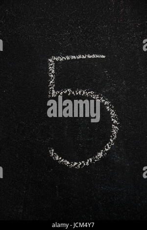 Number 5, five drawn with white chalk on blackboard. Education, school concept Stock Photo