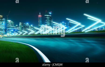 Motion blurred racetrack with city skyline background ,night scene cold mood. with arrow light Effects. Stock Photo