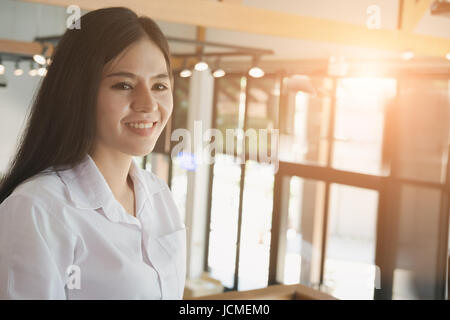 service woman standing and smiling at cafe coffee shop. portrait of young asian waitress at restaurant Stock Photo