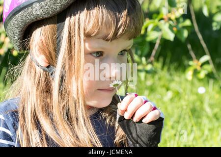 Cute little girl with a daisy portrait, green background, natural Stock Photo