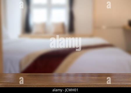 big comfortable double bed in bedroom with selected focus wood table for montage or display your product Stock Photo