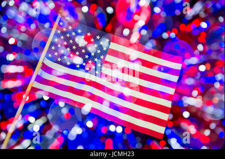 American flag background with double exposure of celebratory bokeh light bubbles like fireworks. Multiple exposure