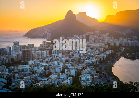 A dramatic skyline view of sunset over Ipanema with Two Brothers Mountain looking over both the Atlantic Ocean and Rodrigo de Freitas lagoon Stock Photo