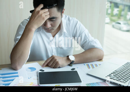 stressed and frustrated young male graphic designer working with computer and color swatch. creative man using stylus pen and digital tablet at modern Stock Photo