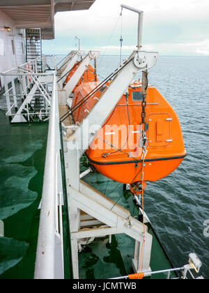 A lifeboat in case of an accident in the port or on a ship. The orange boat. Stock Photo