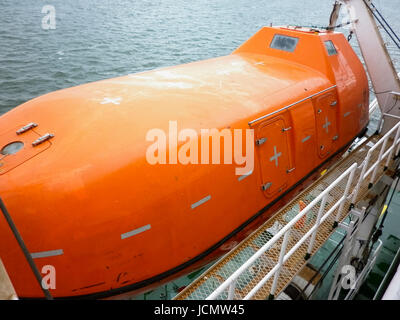 A lifeboat in case of an accident in the port or on a ship. The orange boat. Stock Photo