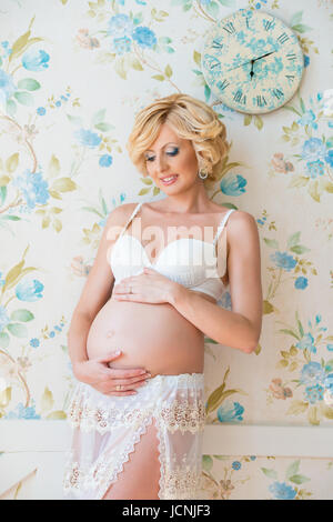 Profile of pregnant woman hugging her belly Stock Photo - Alamy