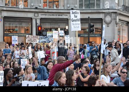 London, UK. 16th June 2017. A protest march pauses and has a sit-in at Oxford Circus, blocking the traffic before continuing through central London in memory of the victims of the Grenfell Tower fire, in which at least 30 people died. The disaster has seen local people and survivors angry at what they see as cost cutting during a recent refurbishment, resulting in potentially flammable cladding being added to the building, and a perceived lack of information as the death toll rises. Credit: Patricia Phillips/Alamy Live News Stock Photo