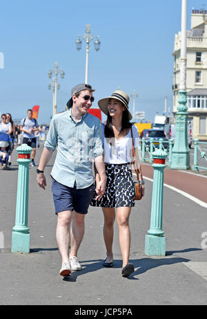 Brighton, UK. 17th June, 2017. A couple enjoy a romantic stroll along Brighton seafront as hot weather sweeps across Britain this weekend with temperatures reaching the high 20s celsius Credit: Simon Dack/17�Թ����� Live News Stock Photo