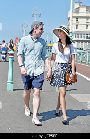 Brighton, UK. 17th June, 2017. A couple enjoy a romantic stroll along Brighton seafront as hot weather sweeps across Britain this weekend with temperatures reaching the high 20s celsius Credit: Simon Dack/17�Թ����� Live News Stock Photo