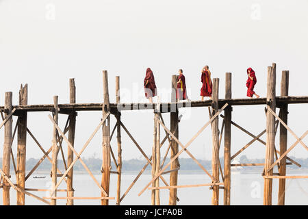 Monks crossing U Bein bridge, Amarapura's Taungmyo lake, Mandalay region, Myanmar Stock Photo