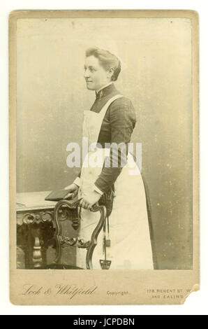 Original Victorian cabinet photograph of Victorian servant, Victorian maid, housemaid or parlourmaid wearing a sewing repair kit circa early 1890's, London, UK Stock Photo