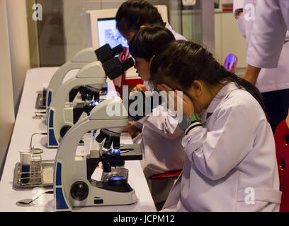 Bangkok, Thailand - April 29, 2017: Asian kids looking through microscope in chemistry class