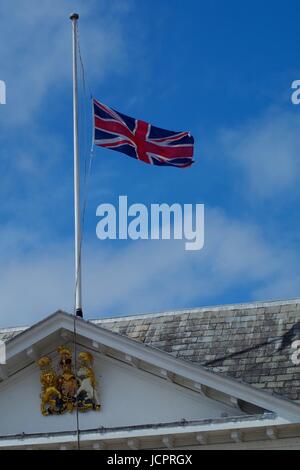 The Union Jack Flying at Half Mast above The Royal Coat of Arms on Exeter's Custom House. Exeter Quay, Devon, UK. June, 2017. Stock Photo