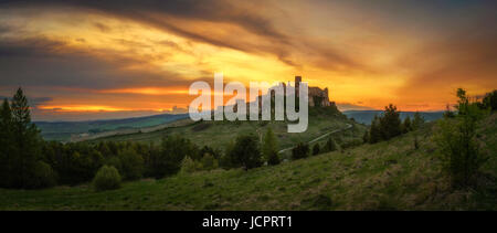 Dramatic sunset panorama of the ruins of Spis Castle in Slovakia.  Spis Castle is a national monument and one of the biggest European castles by area. Stock Photo