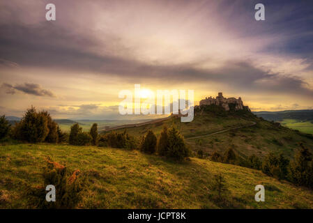 Sunset over the ruins of Spis Castle in Slovakia.  Spis Castle is a national monument and one of the biggest European castles by area. Stock Photo
