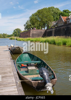 Jetty with boats on river Afgedamde Maas and city wall of old fortified town of Woudrichem, Brabant, Netherlands Stock Photo