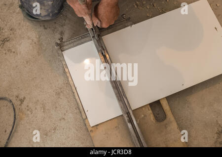 Ceramist cuts tile cutter tile, cut to an appropriate dimension, white tiles, ceramics Stock Photo