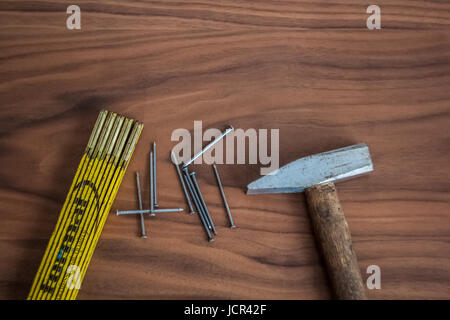 Hammer, nails and meter stick on a wooden table desk Stock Photo