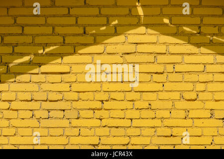 Yellow brick wall texture with roof shadows Stock Photo