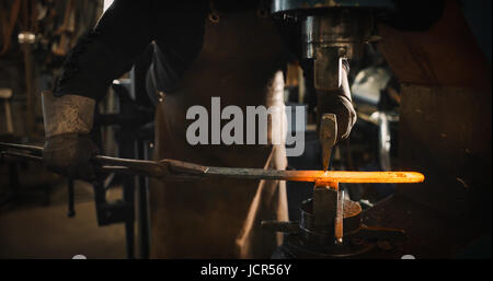 Rod hot iron on the anvil ready to be beaten. Stock Photo