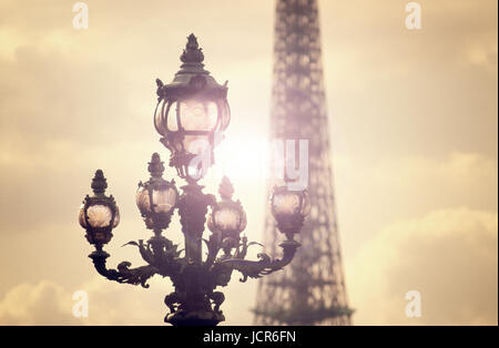 PARIS PONT ALEXANDRE III SUNSET ART NOUVEAU LAMPS - Sunburst behind ornate Art Nouveau lamps on Alexandre III bridge with Eiffel Tower in background 'City of Light' Les Invalides Paris France Stock Photo