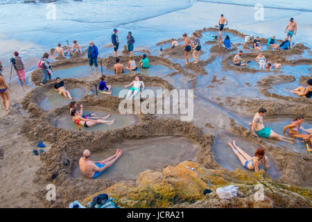NORTH ISLAND, NEW ZEALAND- MAY 16, 2017: Visitors making small hot water pools in Hot Water beach.it one of the most popular geothermal attractions in
