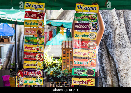Young woman hanging signs at a fesh juice cafe in Oaxaca, Mexico Stock Photo