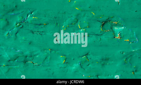 Old cracked paint pattern on rusty background. Peeling green grunge material. Damaged metal surface. Scratched plate. Stock Photo