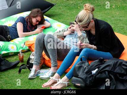 Young women on mobile phones at Taste of Dublin Stock Photo