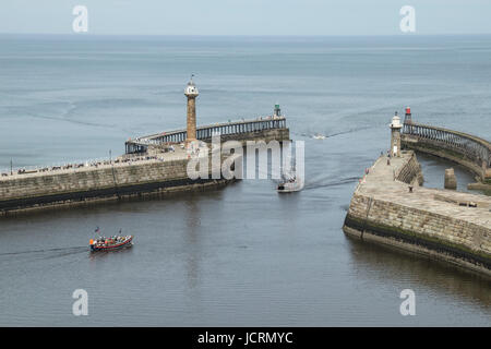 The sailing boat Bark Endeavour and the old lifeboat exiting Whitby Harbour at Whitby, North Yorkshire, UK Stock Photo