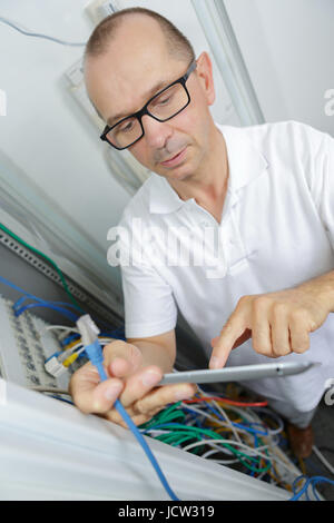 technician using tablet while analysing server Stock Photo