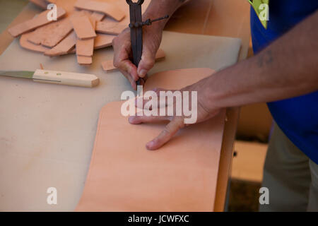 Indigenous Colombian leatherworker scoring leather using a wing divider Stock Photo