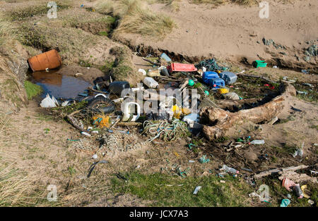 A variety of flotsam & jetsom including tangled rope, netting and plastic items washed up on a beach on the west coast of Anglesey in North Wales. Stock Photo