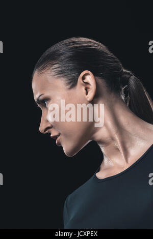 side view portrait of attractive young woman isolated on black. Stock Photo