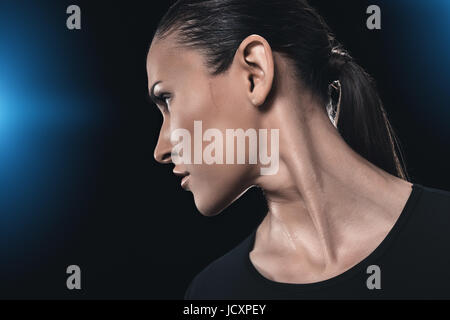 side view portrait of attractive young woman isolated on black. Stock Photo