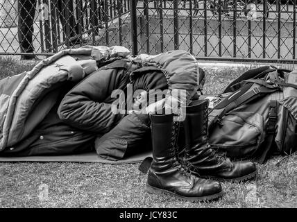 PARIS FRANCE - MAN HAVING SOME REST IN IT'S SLEEPING BAG IN A SQUARE OF THE CITY - PARIS HOMELESS - STREET PHOTOGRAPHY © Frédéric BEAUMONT Stock Photo