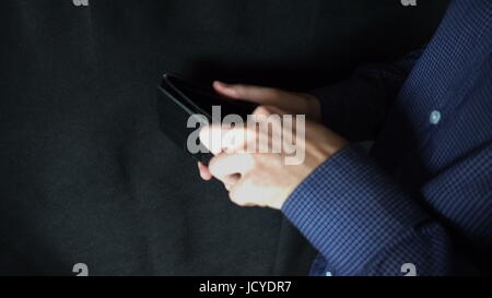 Taking Money Out of a Purse. The man opens a leather purse and pulls out a dollar bill. Stock Photo