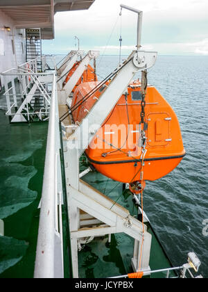 A lifeboat in case of an accident in the port or on a ship. The orange boat. Stock Photo