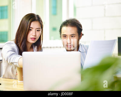 young asian business people team working together in office using laptop computer. Stock Photo