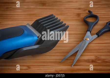 Hair clipper with scissors (shears) on a wooden table. Close up. Stock Photo