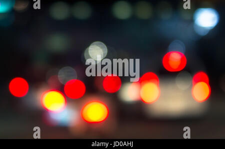 Defocus car tail lights in the night traffic. The shot was taken by altering the lens focus ring. Stock Photo